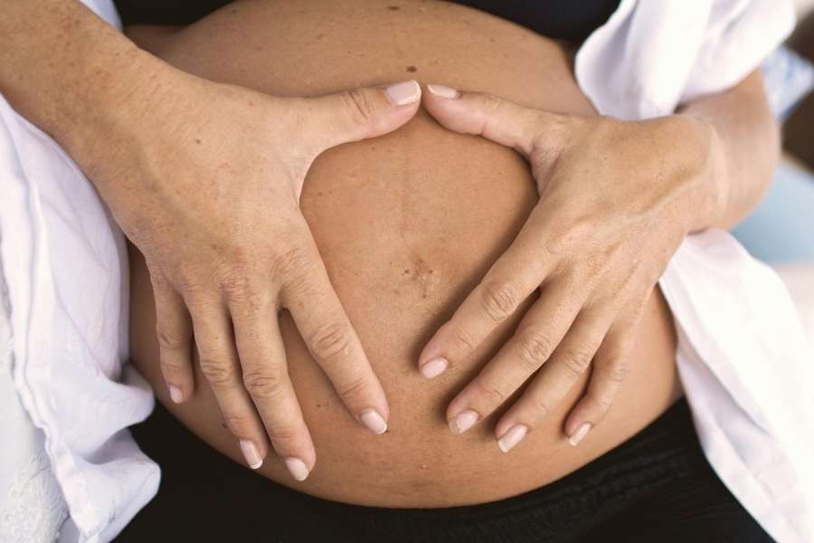 Massage prénatal du ventre avec gestes doux pour femme enceinte